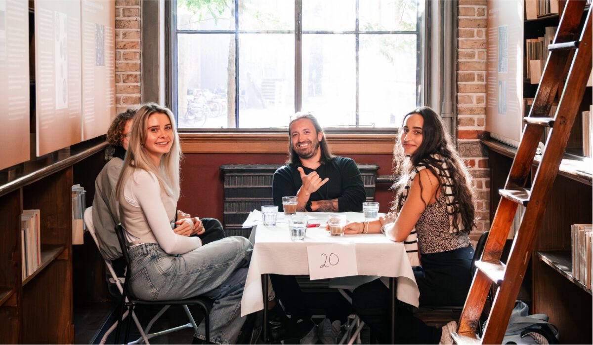 Four students seated around a table in a library.